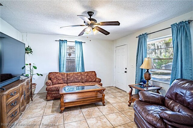 living room featuring light tile patterned floors, a textured ceiling, and ceiling fan