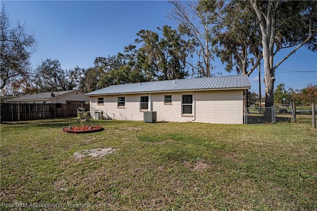 back of property with a yard and central AC unit