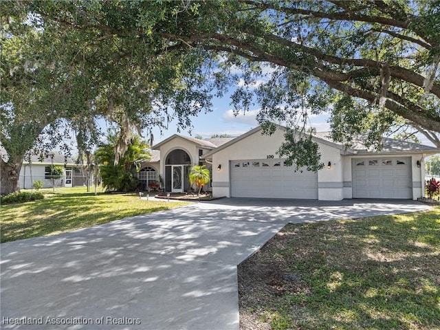 single story home featuring an attached garage, driveway, a front yard, and stucco siding