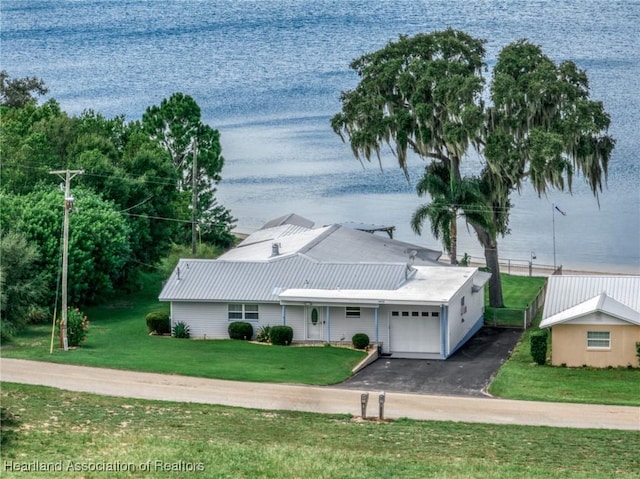 view of front of property featuring a water view, a garage, and a front lawn