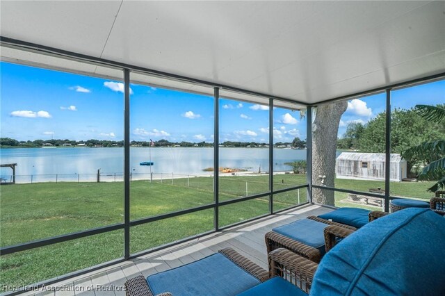 unfurnished sunroom featuring plenty of natural light and a water view