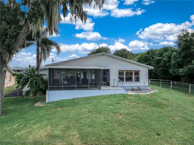 back of house with a lawn and a sunroom