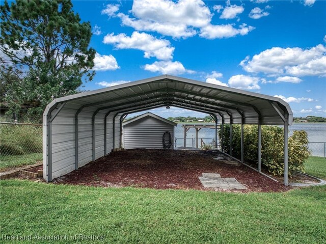 view of parking / parking lot with a water view, a carport, and a lawn