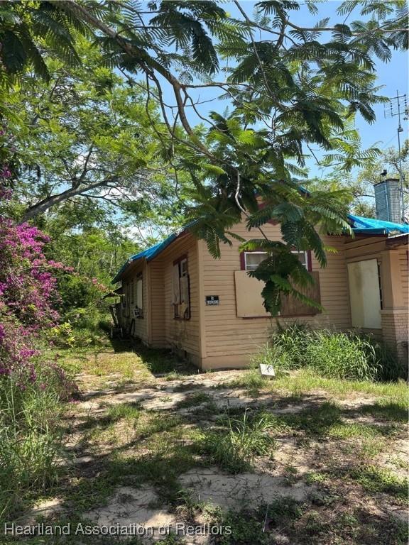 607 S Willow Ave, Avon Park, FL 33825 - view of side of home with a chimney
