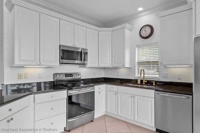 6831 Sun Blvd N, Sebring, FL 33872 - kitchen with stainless steel appliances, a sink, white cabinets, ornamental molding, and light tile patterned floors