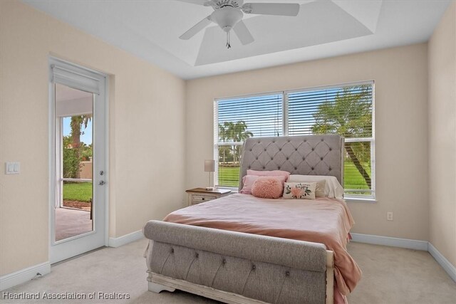6831 Sun Blvd N, Sebring, FL 33872 - bedroom with access to exterior, light colored carpet, a tray ceiling, and baseboards