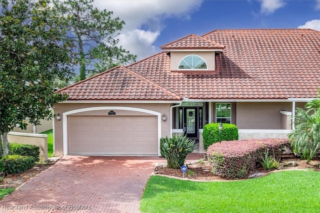 6831 Sun Blvd N, Sebring, FL 33872 - mediterranean / spanish home with stucco siding, a tile roof, a garage, decorative driveway, and a front yard