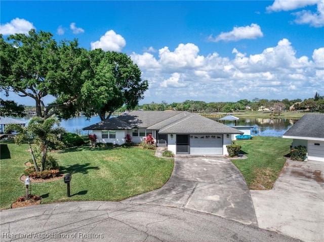 2 Chickasaw St, Lake Placid, FL 33852 - ranch-style home with an attached garage, concrete driveway, a front lawn, and a water view