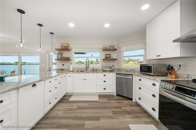 2 Chickasaw St, Lake Placid, FL 33852 - kitchen featuring a sink, white cabinets, stainless steel appliances, wall chimney exhaust hood, and open shelves