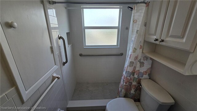 bathroom featuring a shower with shower curtain and toilet