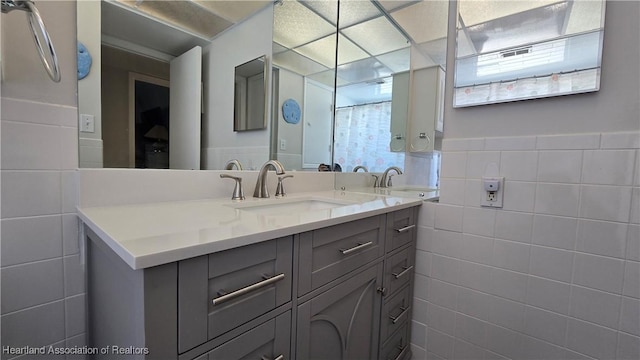 bathroom featuring vanity and tile walls