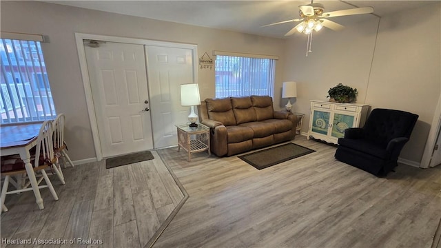 living room featuring wood-type flooring and ceiling fan