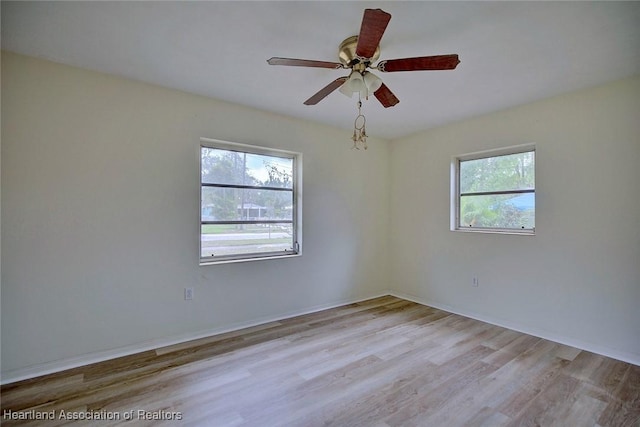 spare room featuring wood finished floors and a ceiling fan