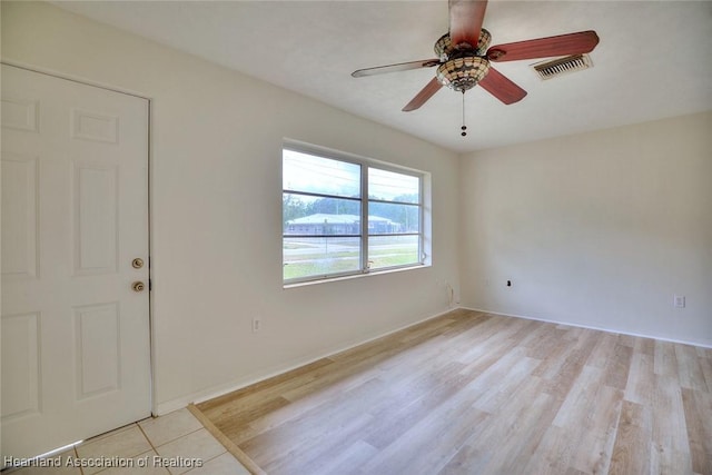 empty room with visible vents, light wood-type flooring, and ceiling fan