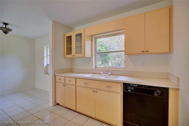 kitchen with dishwasher, light countertops, light brown cabinets, and a sink