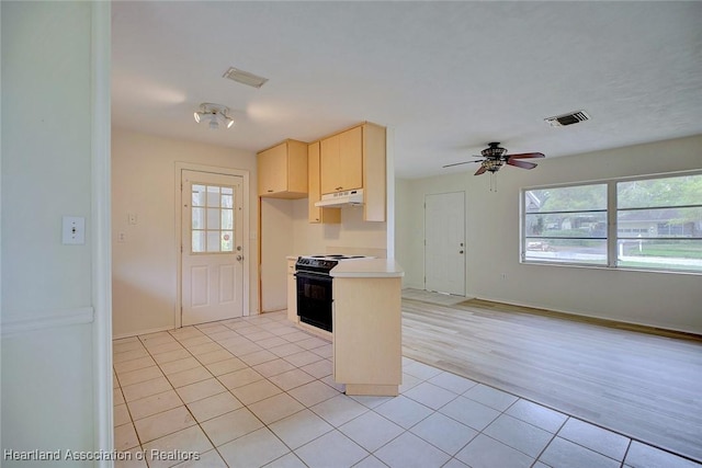 kitchen with under cabinet range hood, light brown cabinets, visible vents, and black electric range oven