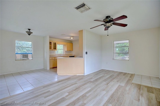 unfurnished living room featuring a ceiling fan, visible vents, and light wood-type flooring