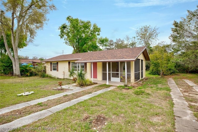 ranch-style home featuring a front yard and a sunroom