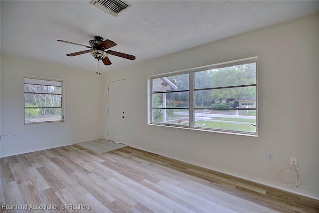 empty room with visible vents, ceiling fan, and light wood-style floors