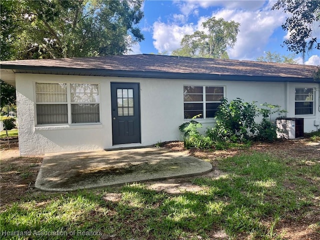 2527 Davis Cir, Sebring, FL 33870 - back of property featuring stucco siding, a patio area, central air condition unit, and roof with shingles