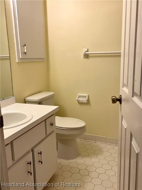 2527 Davis Cir, Sebring, FL 33870 - half bath featuring tile patterned flooring, vanity, toilet, and baseboards