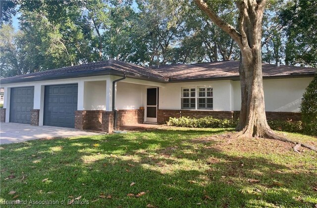 2527 Davis Cir, Sebring, FL 33870 - ranch-style house with brick siding, a garage, concrete driveway, and stucco siding