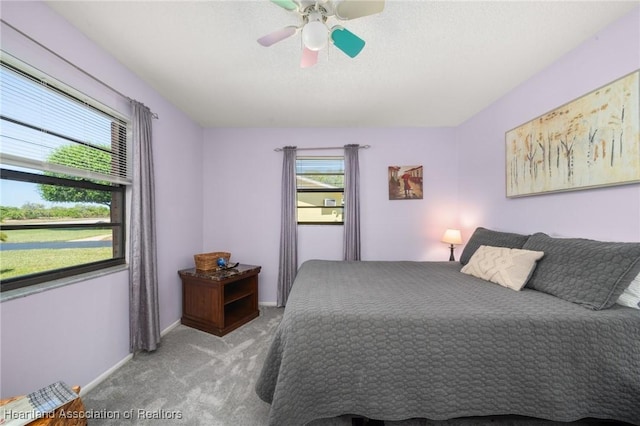 carpeted bedroom with baseboards and a ceiling fan