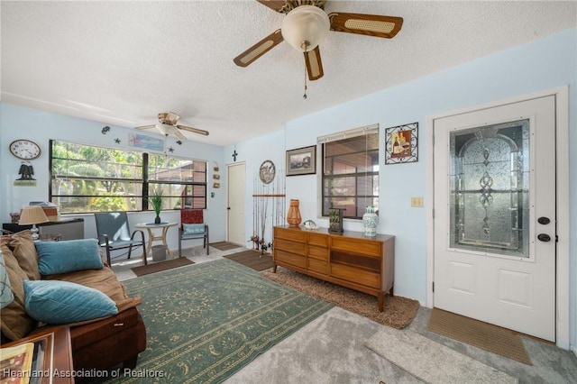 interior space featuring carpet flooring, a textured ceiling, and ceiling fan