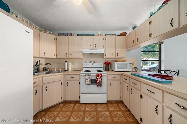 kitchen featuring white appliances, ceiling fan, light countertops, under cabinet range hood, and a textured ceiling