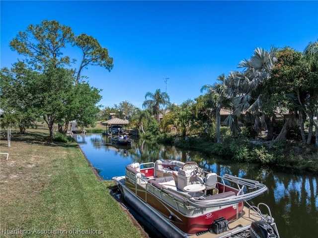 dock area with a lawn and a water view