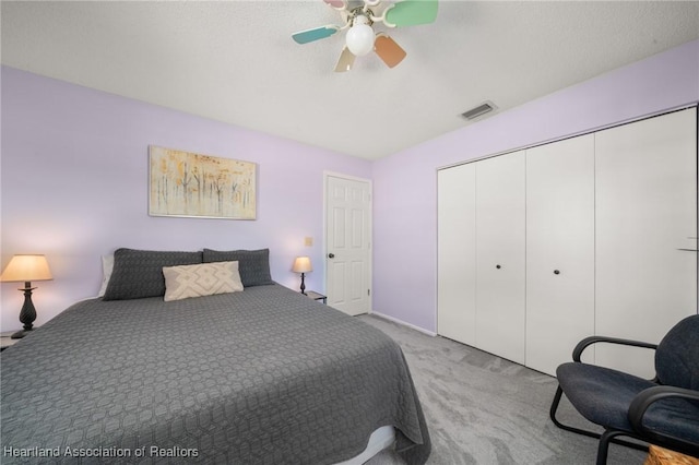 bedroom with visible vents, vaulted ceiling, carpet floors, a closet, and a ceiling fan