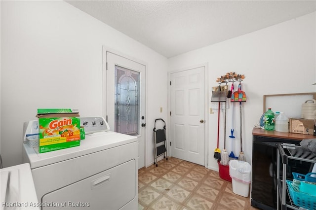 washroom featuring a textured ceiling, light floors, laundry area, and washer and clothes dryer