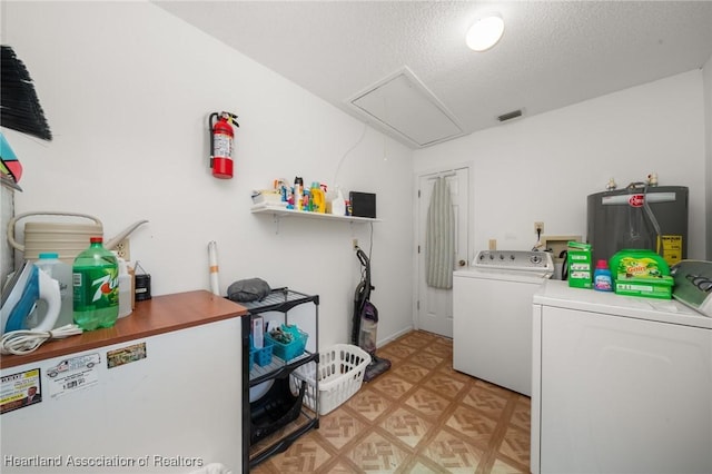 washroom with visible vents, laundry area, attic access, water heater, and washing machine and dryer