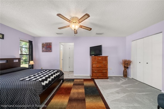 bedroom featuring carpet, visible vents, a closet, and a textured ceiling