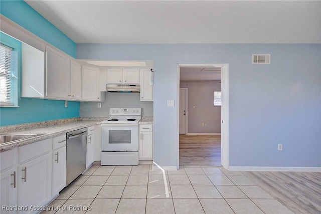 kitchen with electric range, dishwasher, sink, light tile patterned floors, and white cabinets