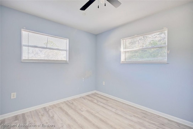 spare room featuring light wood-type flooring, plenty of natural light, and ceiling fan