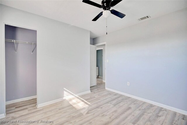 unfurnished bedroom with ceiling fan, a closet, and light hardwood / wood-style flooring