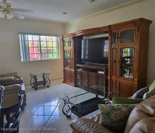 living room featuring a ceiling fan, light tile patterned flooring, crown molding, baseboards, and a textured ceiling