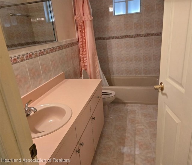 full bath featuring tile patterned floors, toilet, tile walls, shower / tub combo, and vanity