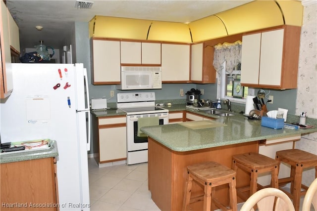 3603 Herring Ave, Sebring, FL 33870 - kitchen with visible vents, a sink, white appliances, a peninsula, and light tile patterned flooring