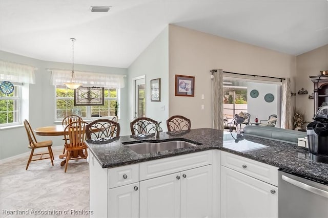 kitchen with dishwasher, decorative light fixtures, white cabinetry, dark stone countertops, and vaulted ceiling