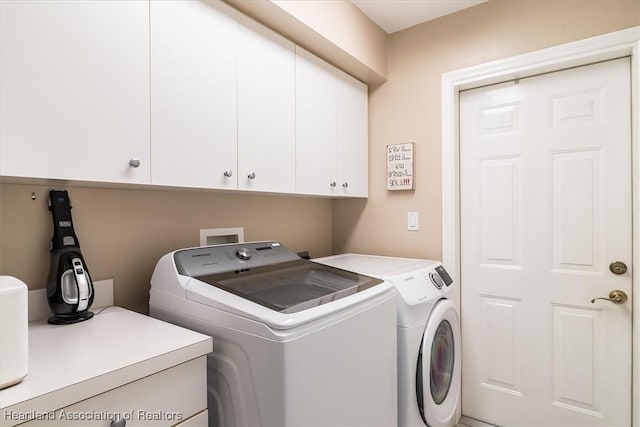 laundry area featuring cabinets and washing machine and clothes dryer