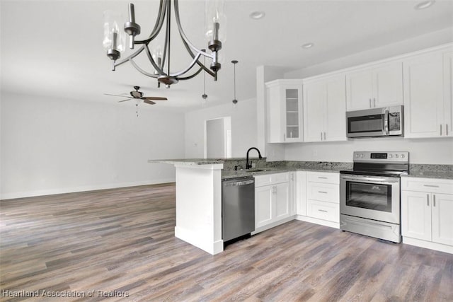 kitchen featuring kitchen peninsula, appliances with stainless steel finishes, ceiling fan with notable chandelier, and white cabinetry