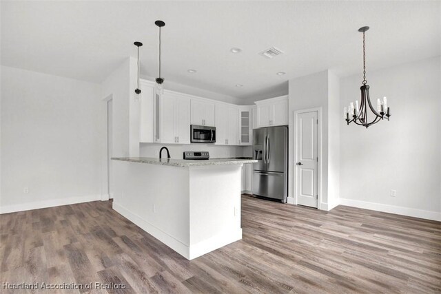 kitchen with white cabinets, pendant lighting, kitchen peninsula, and appliances with stainless steel finishes