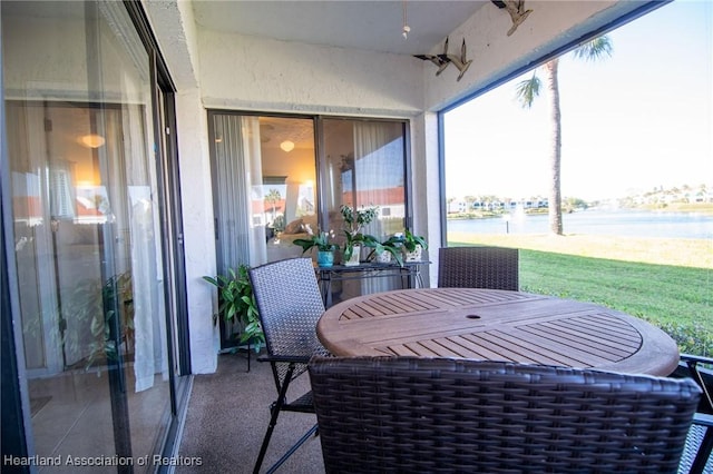 sunroom featuring a water view