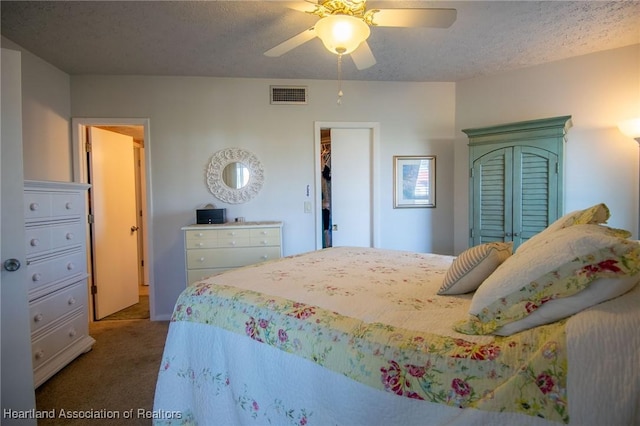 carpeted bedroom with ceiling fan, a textured ceiling, and a closet