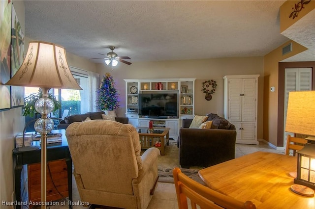 tiled living room with a textured ceiling and ceiling fan