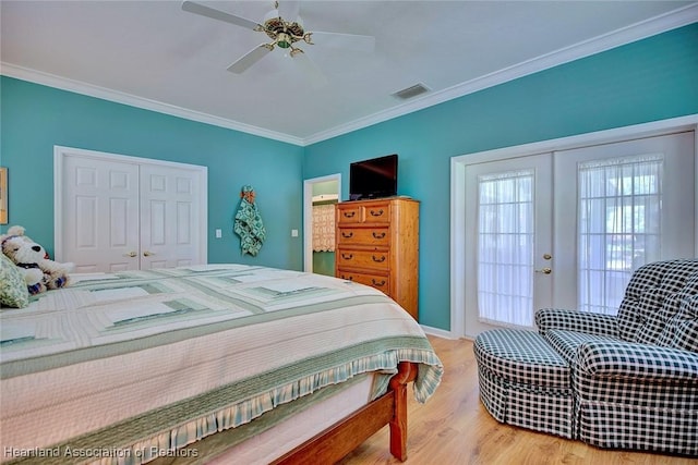 bedroom with visible vents, wood finished floors, a closet, french doors, and crown molding