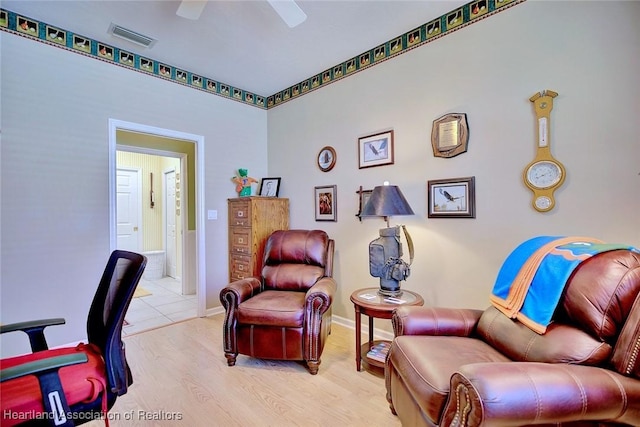 home office featuring a ceiling fan, wood finished floors, visible vents, and baseboards