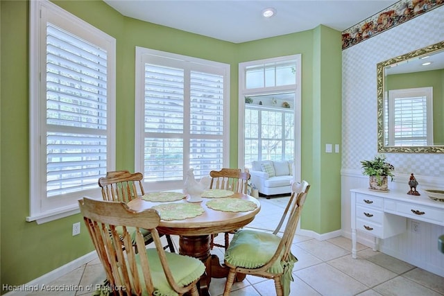 dining area featuring wallpapered walls, plenty of natural light, light tile patterned flooring, and baseboards